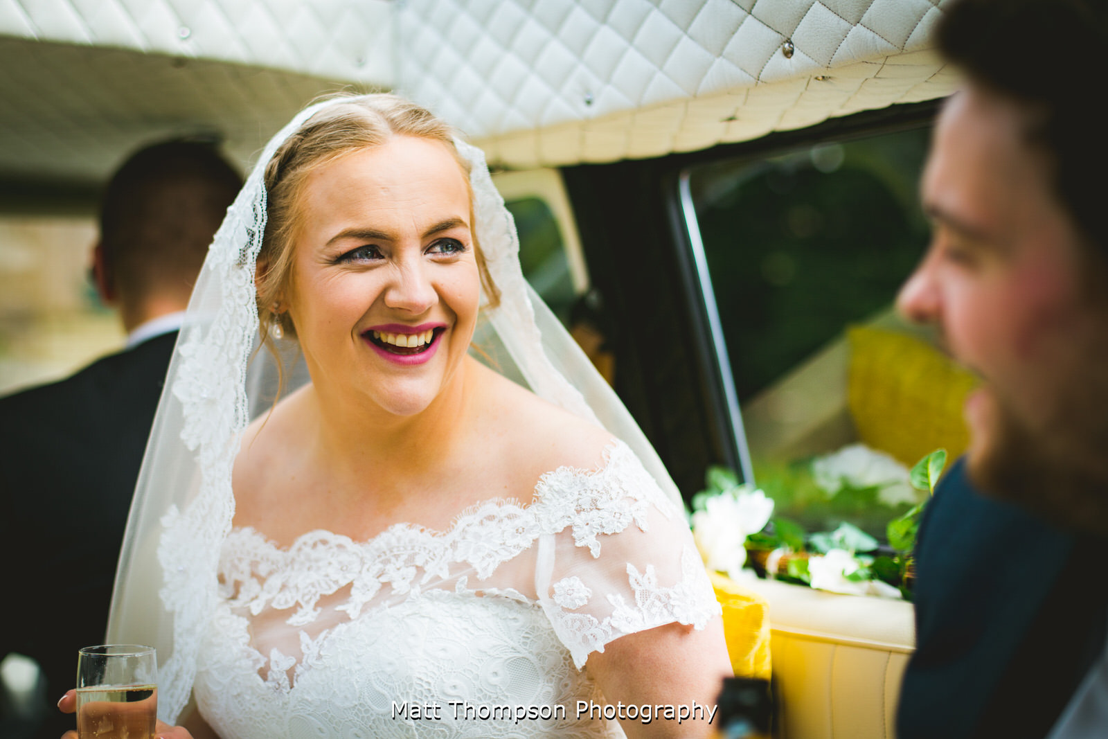 bride smiling in her wedding car