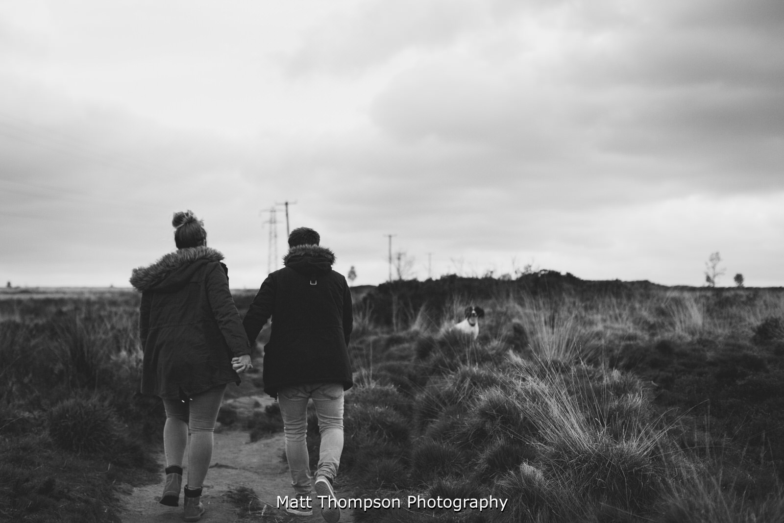engaged couple walking dog