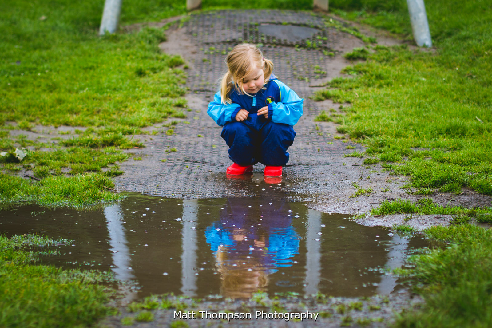 small child staring at puddle