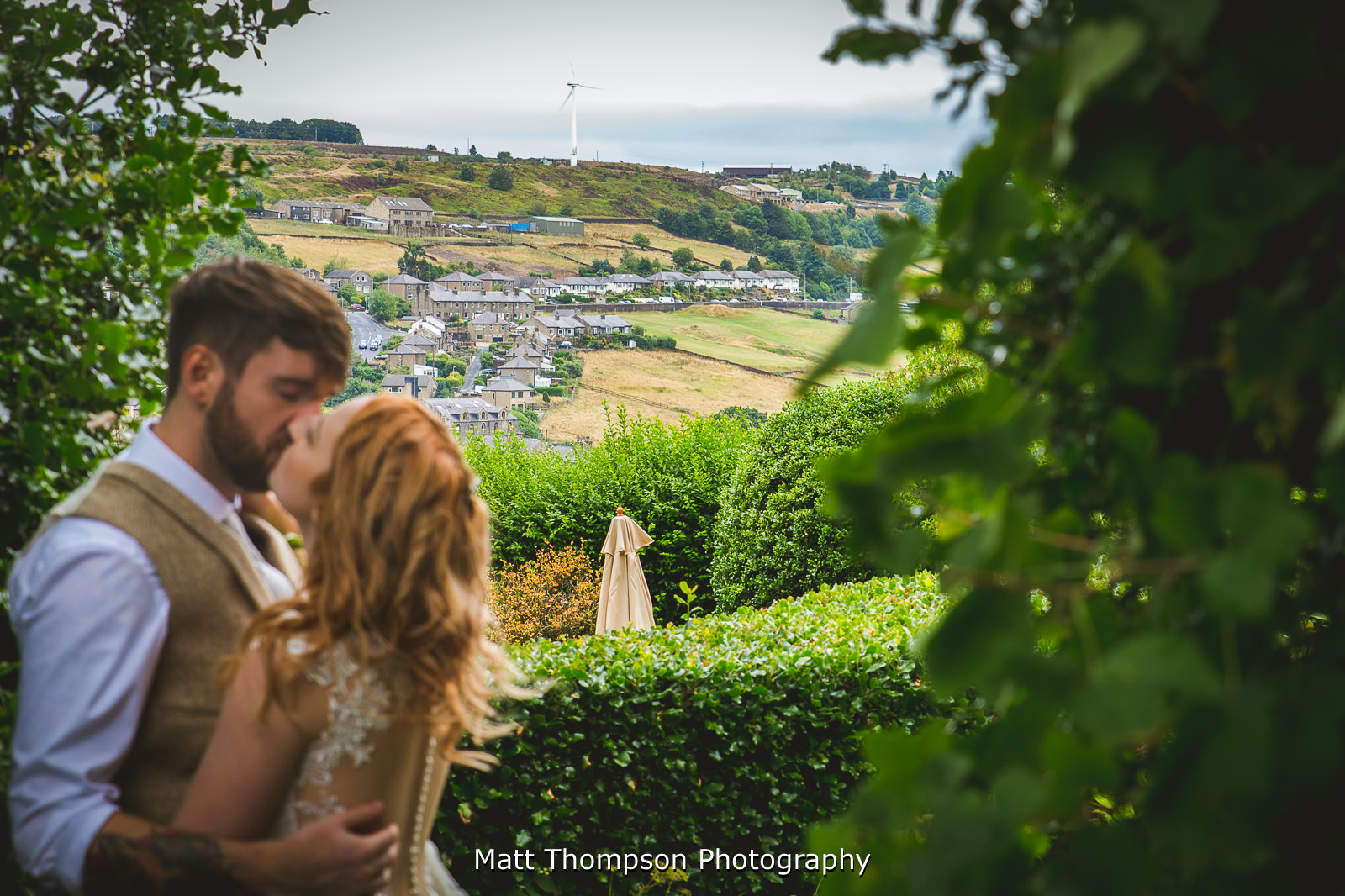 yorkshire hills while bride and groom kiss