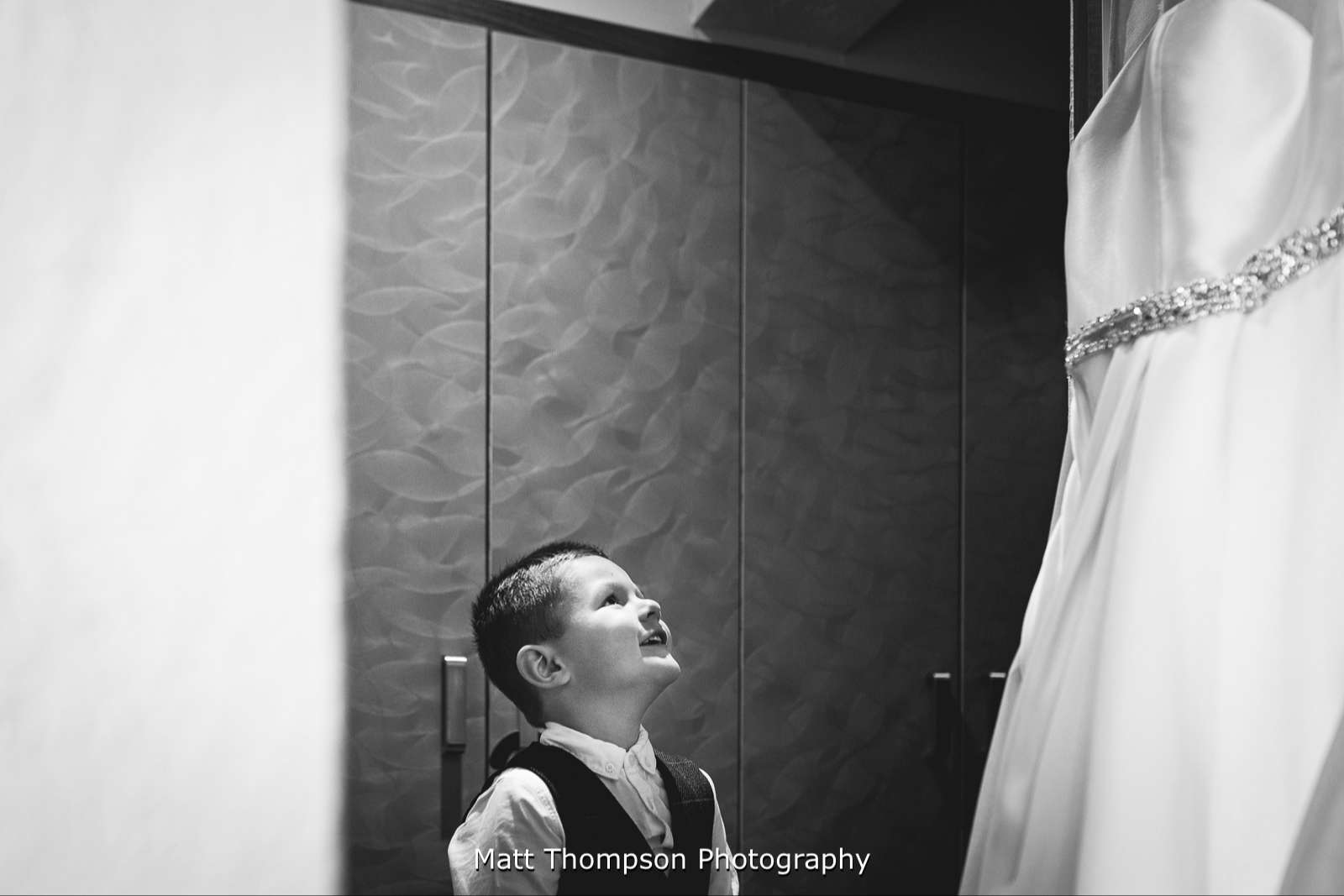 Page boy looking at wedding dress