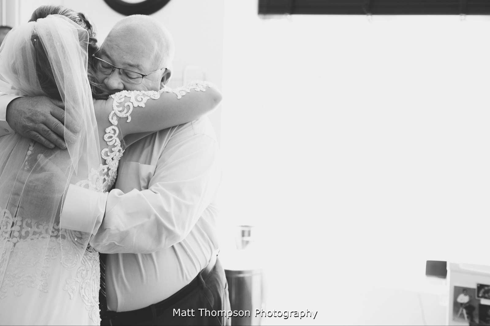 Father of the bride hugging daughter