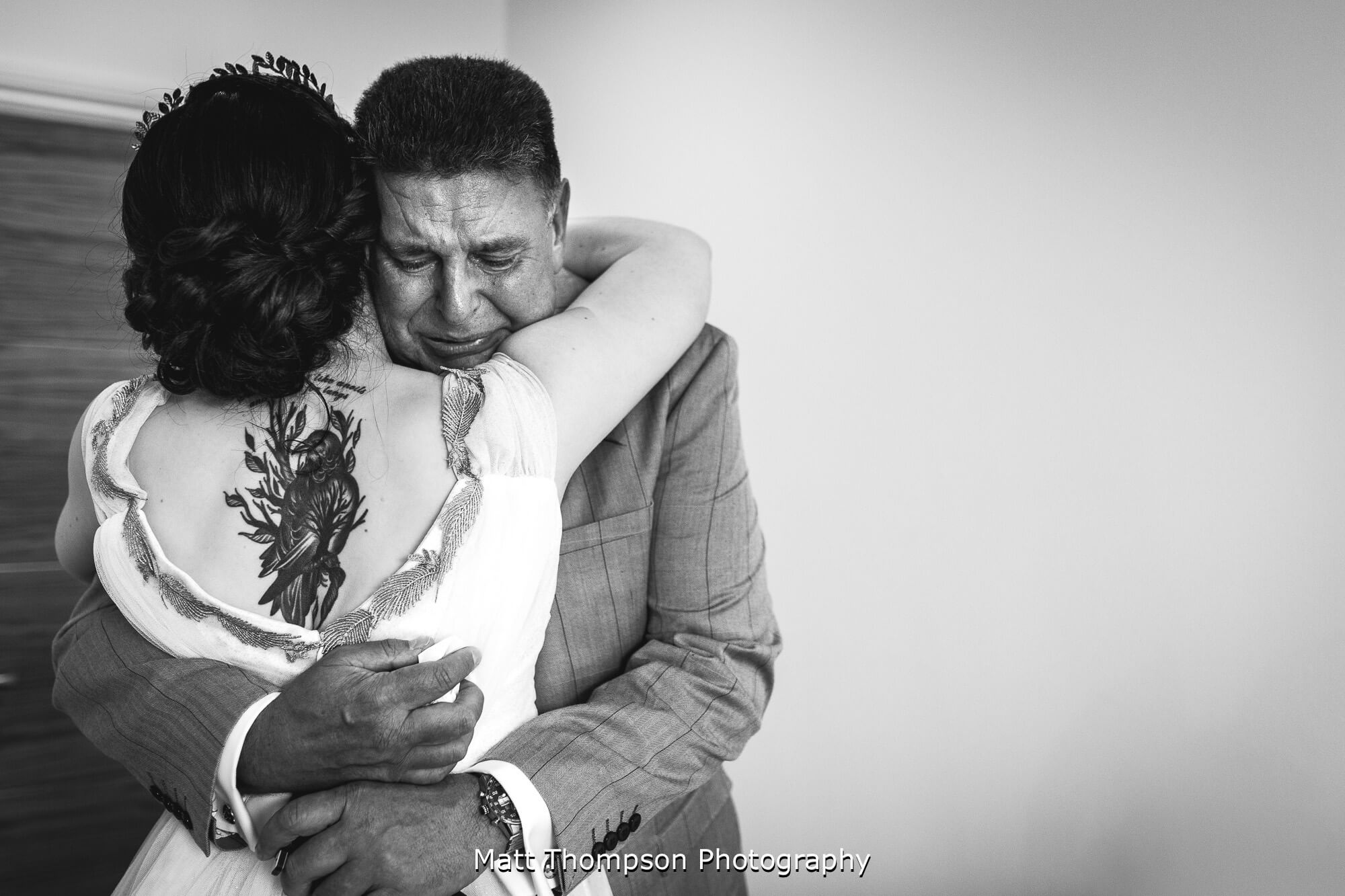 Bride and father of the bride hugging