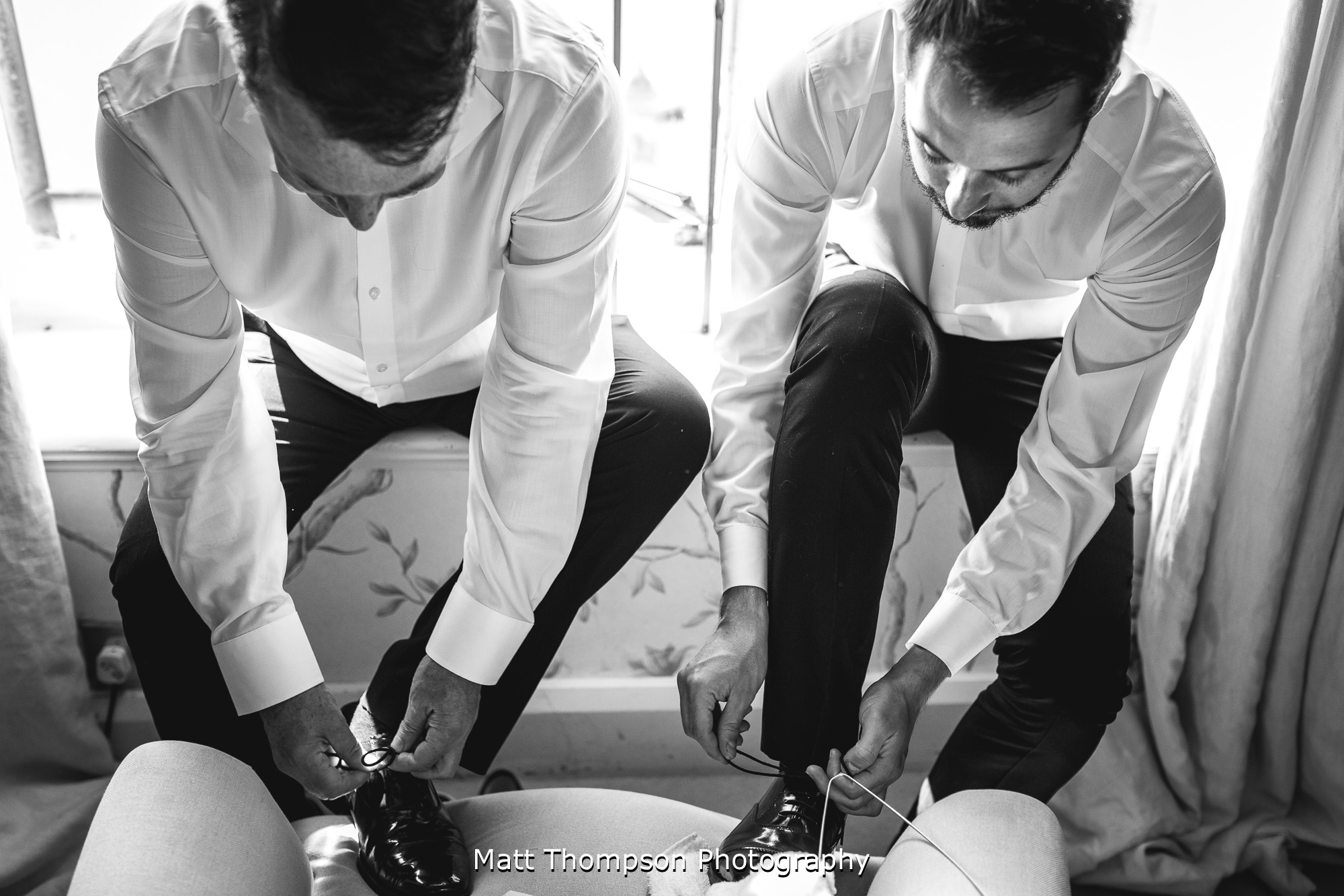groomsmen doing their shoes