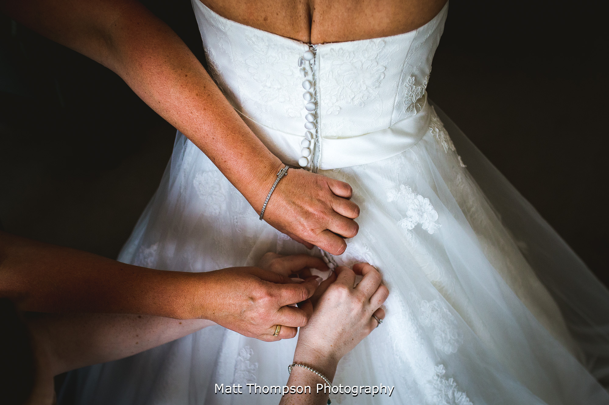 buttoning up the wedding dress