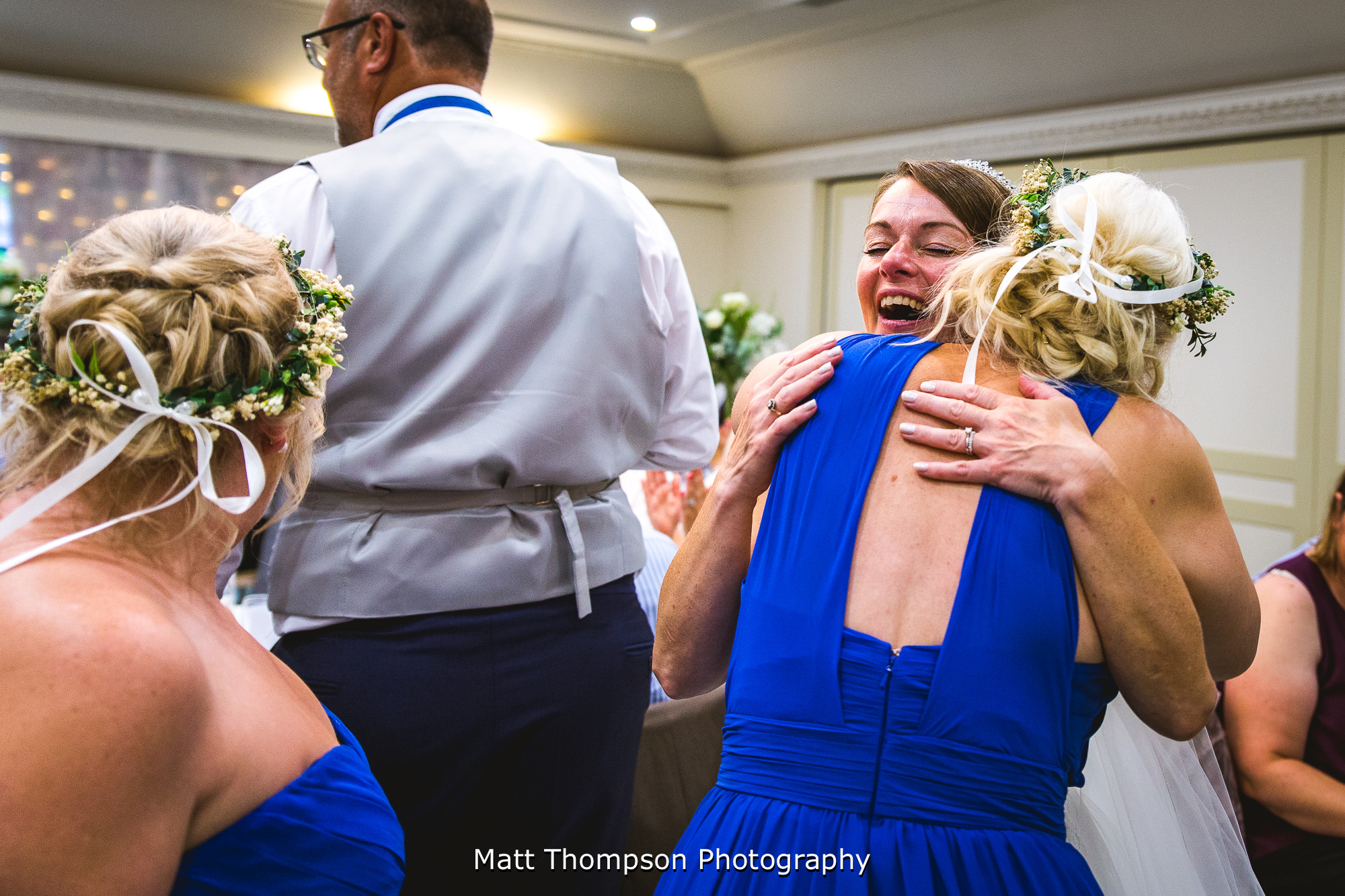 bridesmaids hugging bride