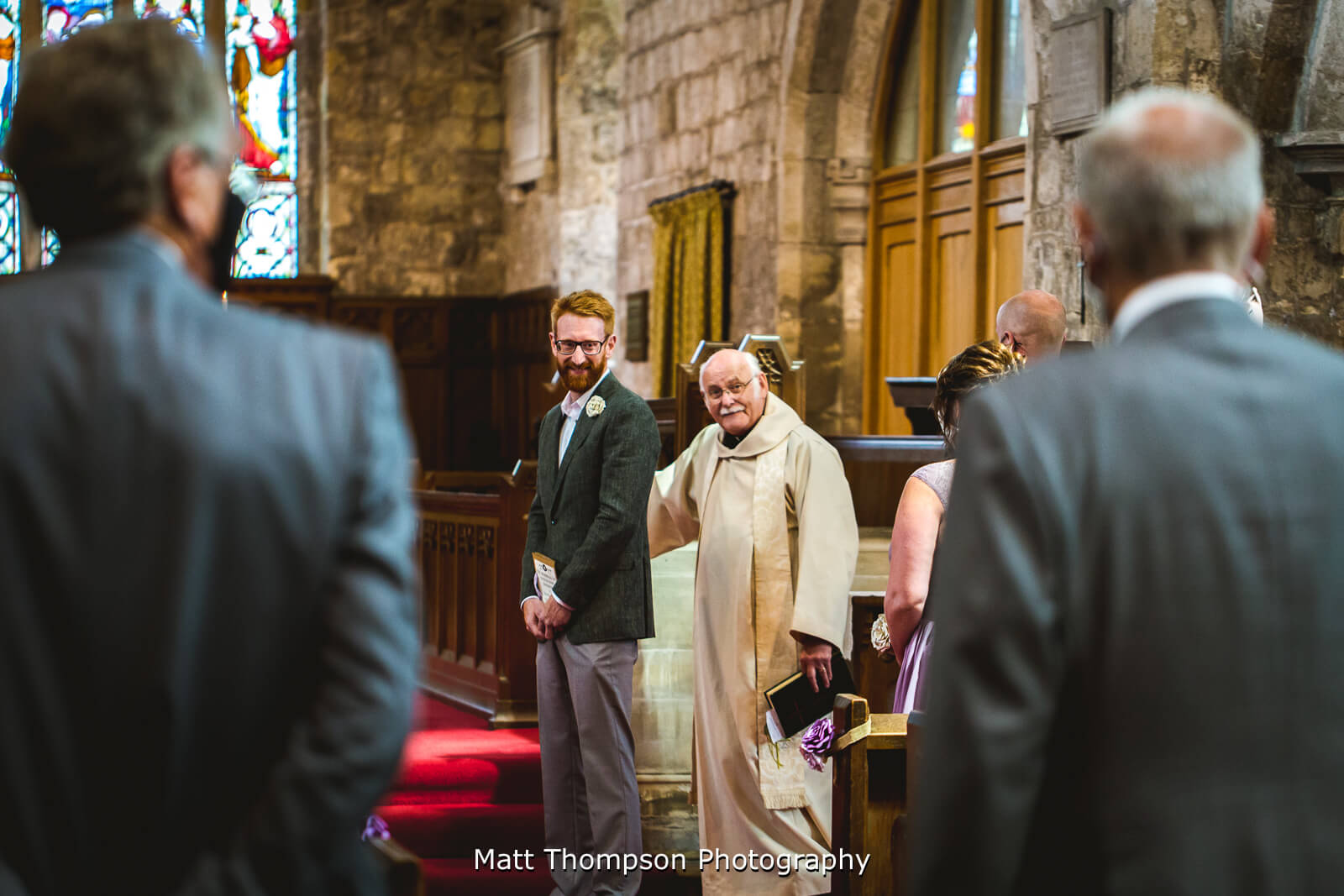 Groom watching bride walk down the aisle